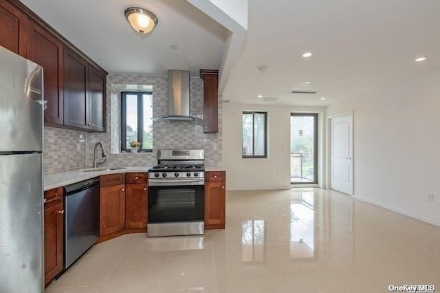 kitchen featuring sink, a wealth of natural light, wall chimney exhaust hood, and stainless steel appliances