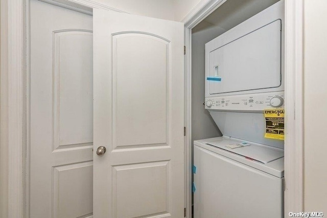 clothes washing area with stacked washer and dryer