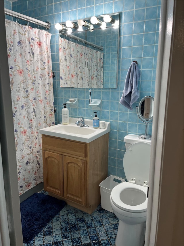 bathroom with tile walls, toilet, vanity, and a shower with shower curtain