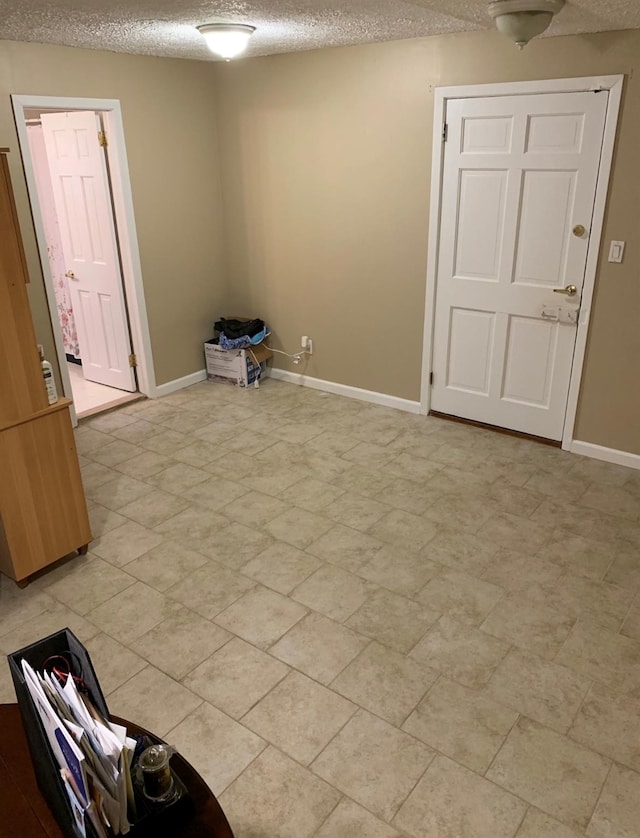 unfurnished room featuring a textured ceiling