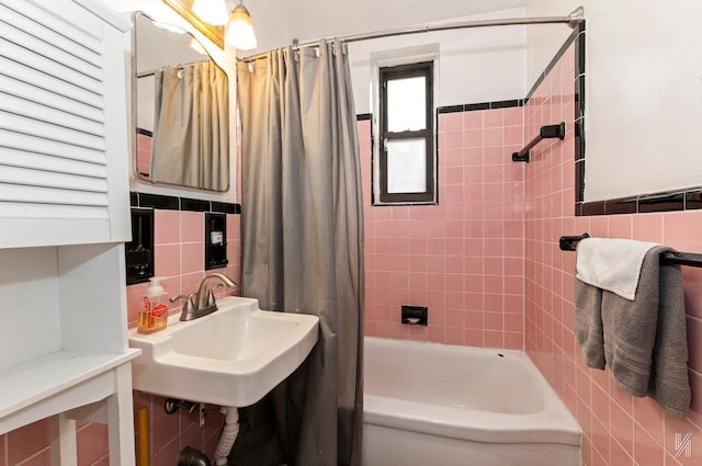 bathroom with tile walls, shower / bath combination with curtain, backsplash, and sink