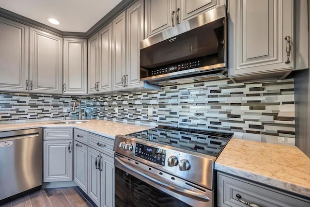 kitchen with sink, gray cabinets, backsplash, and stainless steel appliances