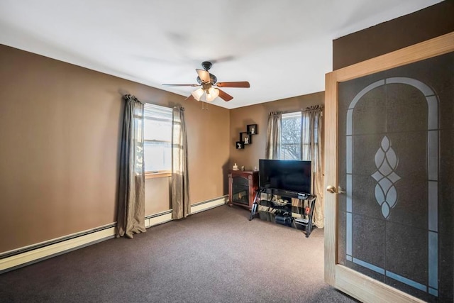 interior space with ceiling fan, carpet floors, and a baseboard heating unit