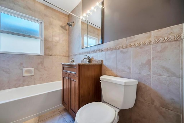 full bathroom with toilet, vanity, a wealth of natural light, and tile walls