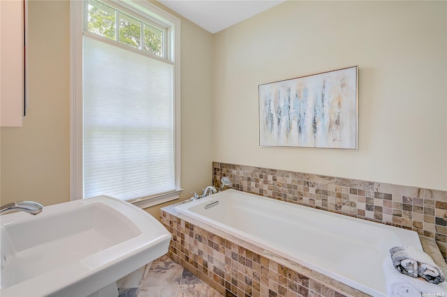 bathroom with tiled bath and sink