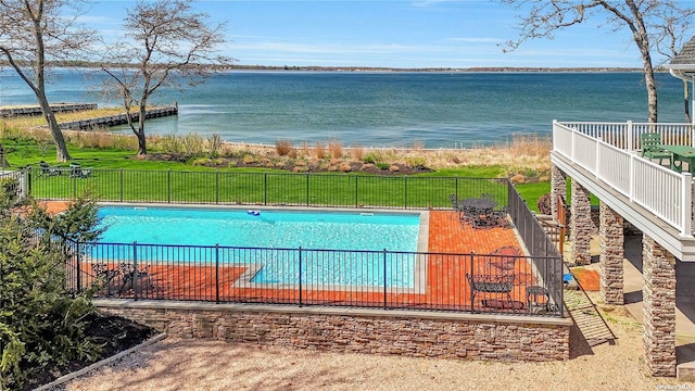 view of pool featuring a water view, a yard, and a patio