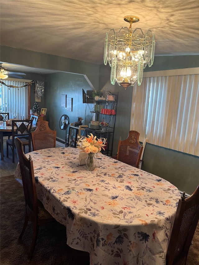 carpeted dining room featuring baseboard heating and a notable chandelier