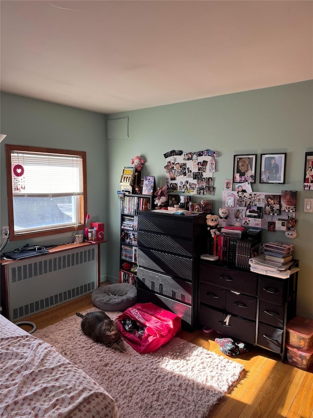 bedroom with radiator and light wood-type flooring