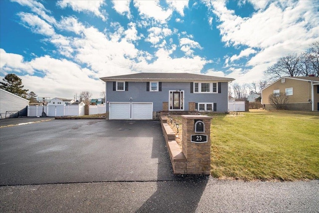 bi-level home with a garage and a front lawn