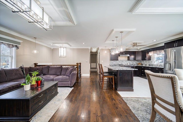 living room with ornamental molding, wood-type flooring, and sink