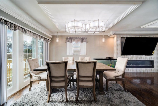 dining area featuring hardwood / wood-style flooring, ornamental molding, and a raised ceiling