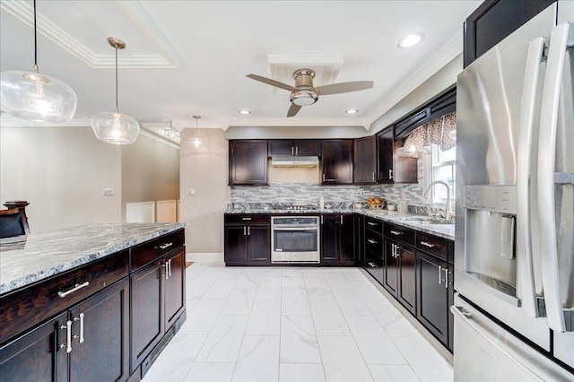 kitchen featuring appliances with stainless steel finishes, pendant lighting, tasteful backsplash, light stone counters, and dark brown cabinets