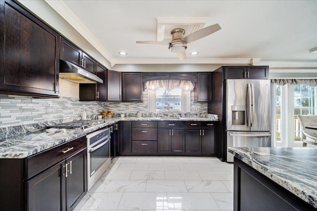 kitchen featuring tasteful backsplash, light stone countertops, appliances with stainless steel finishes, and dark brown cabinets