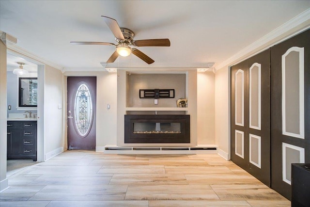 foyer entrance with crown molding, ceiling fan, and sink