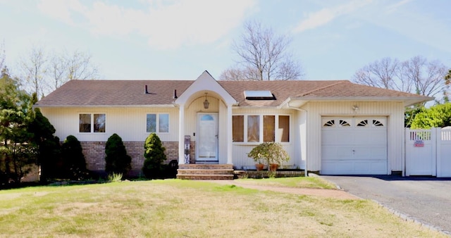 ranch-style house featuring a garage and a front lawn