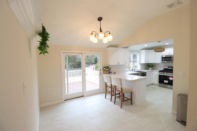 kitchen with a breakfast bar, kitchen peninsula, pendant lighting, stainless steel appliances, and white cabinets