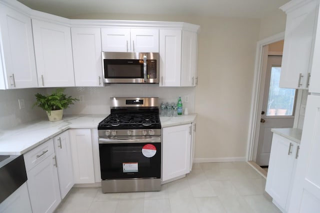 kitchen featuring appliances with stainless steel finishes, light stone countertops, and white cabinets