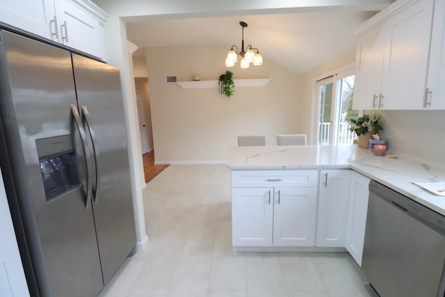 kitchen with appliances with stainless steel finishes, decorative light fixtures, white cabinetry, lofted ceiling, and kitchen peninsula