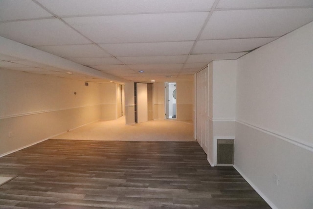 interior space featuring a paneled ceiling and dark hardwood / wood-style flooring