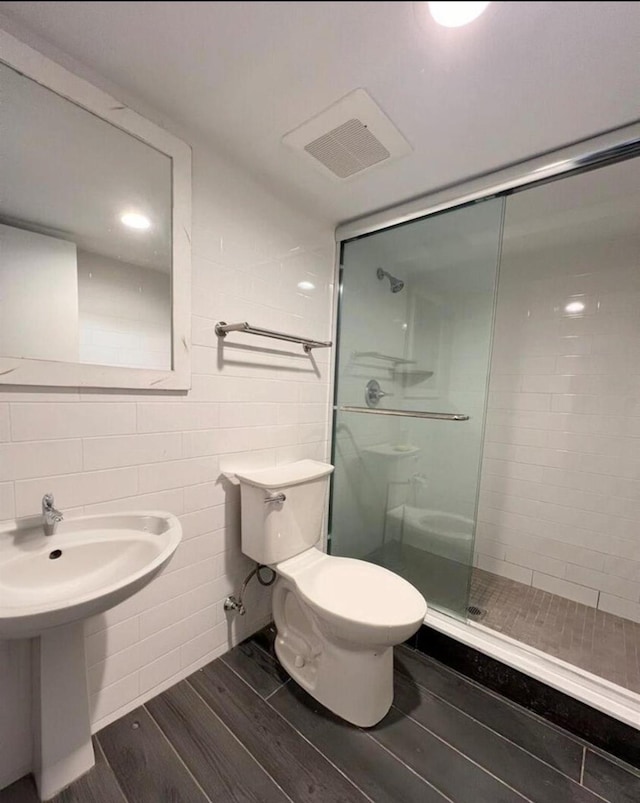 bathroom with toilet and a shower with door