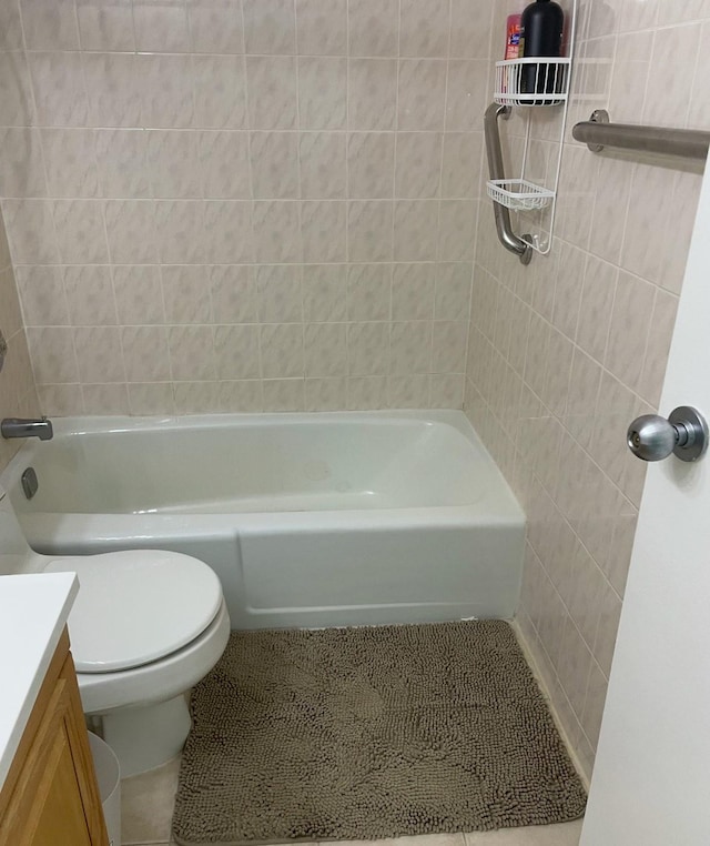 full bathroom featuring toilet, vanity, tile patterned floors, and tiled shower / bath