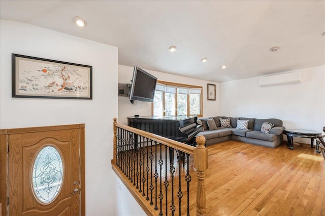 living room with an AC wall unit and hardwood / wood-style flooring