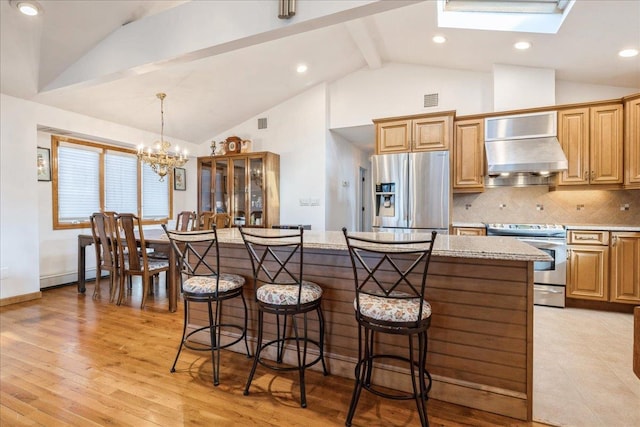 kitchen featuring appliances with stainless steel finishes, a kitchen island, tasteful backsplash, premium range hood, and hanging light fixtures