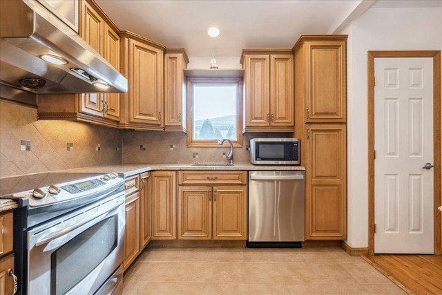 kitchen with tasteful backsplash, light stone countertops, sink, and stainless steel appliances