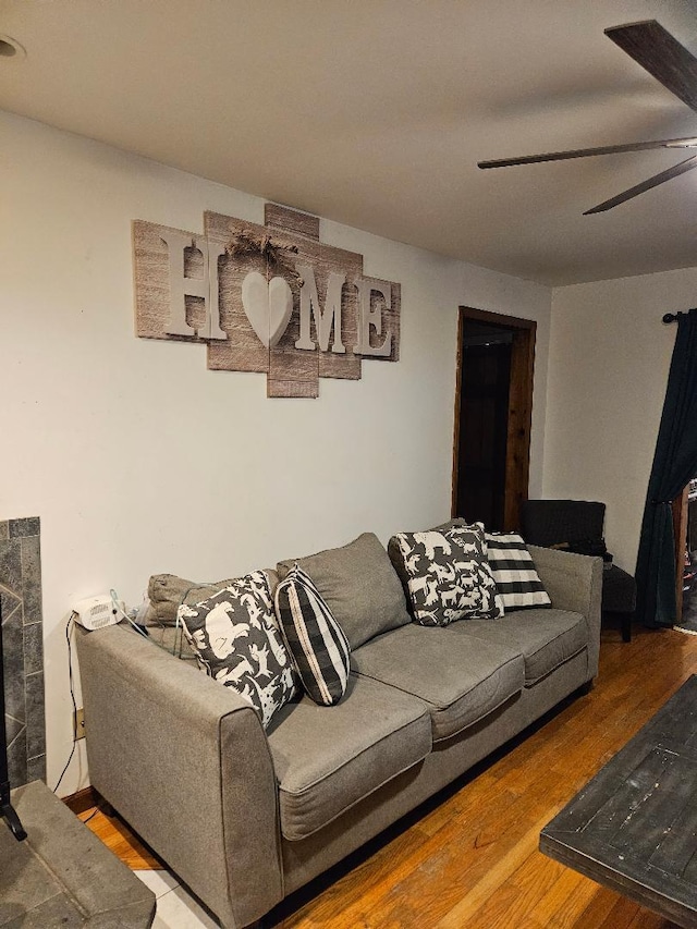 living room featuring hardwood / wood-style flooring, a fireplace, and ceiling fan