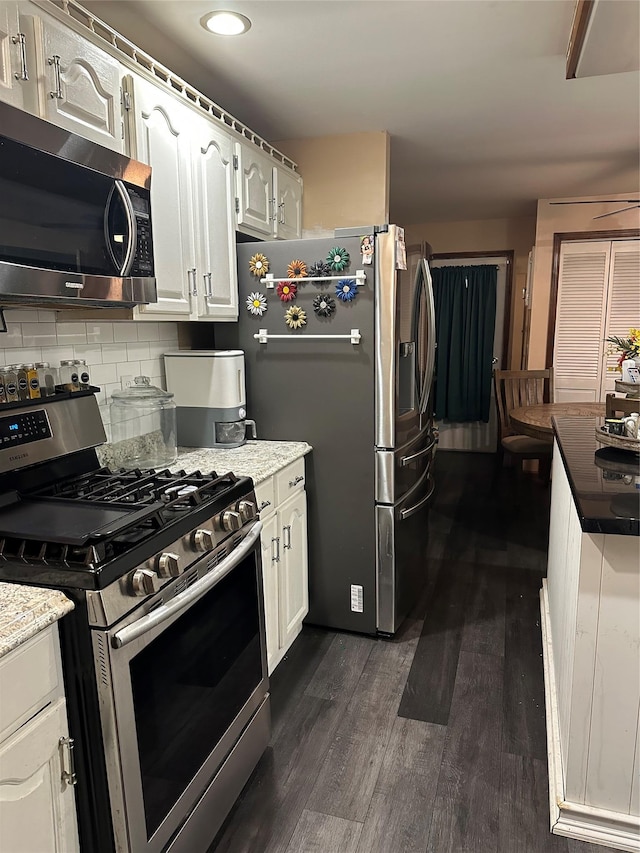 kitchen featuring backsplash, appliances with stainless steel finishes, dark wood-type flooring, and white cabinets