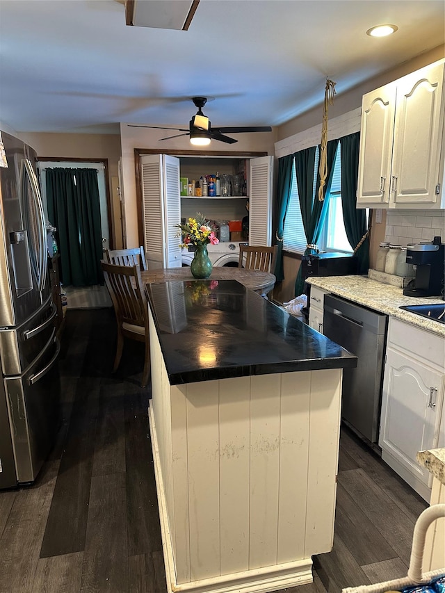 kitchen featuring tasteful backsplash, stainless steel fridge with ice dispenser, dishwashing machine, a kitchen island, and white cabinets