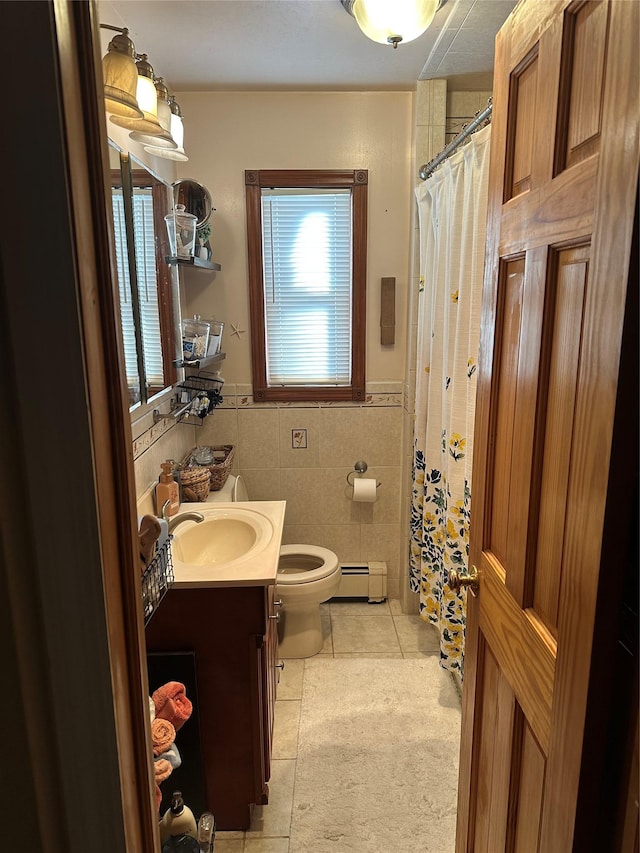 bathroom with tile patterned floors, toilet, tile walls, baseboard heating, and vanity