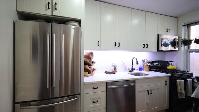 kitchen with tasteful backsplash, stainless steel appliances, sink, and white cabinets