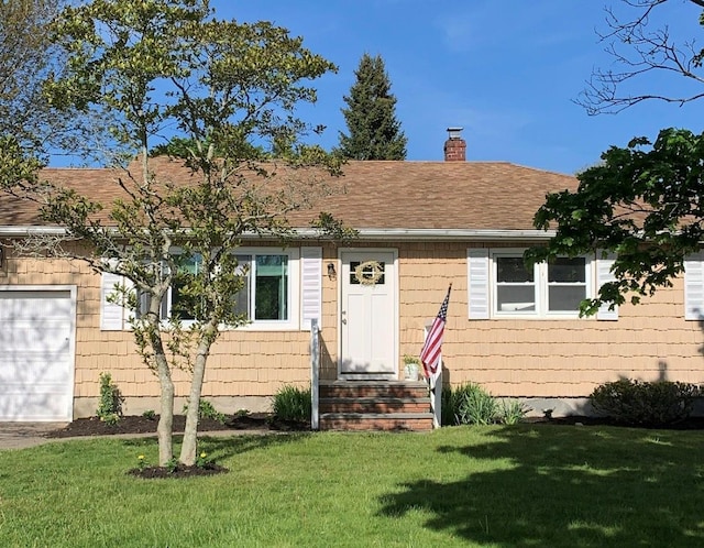 view of front of house featuring a garage and a front lawn