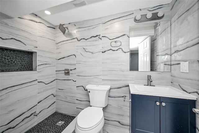 bathroom featuring vanity, toilet, and tiled shower