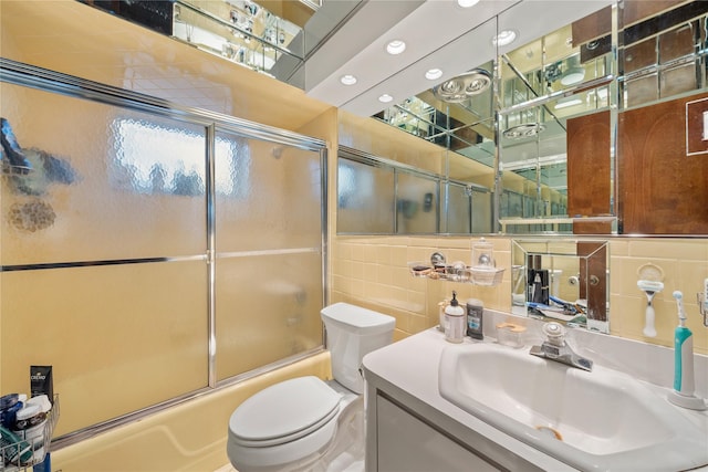 full bathroom featuring toilet, tile walls, shower / bath combination with glass door, vanity, and backsplash