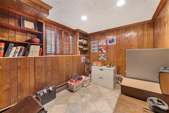 misc room featuring ornamental molding, wood walls, a baseboard heating unit, and a textured ceiling