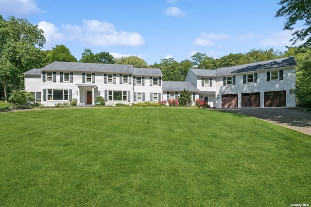 colonial house featuring a front yard and a garage