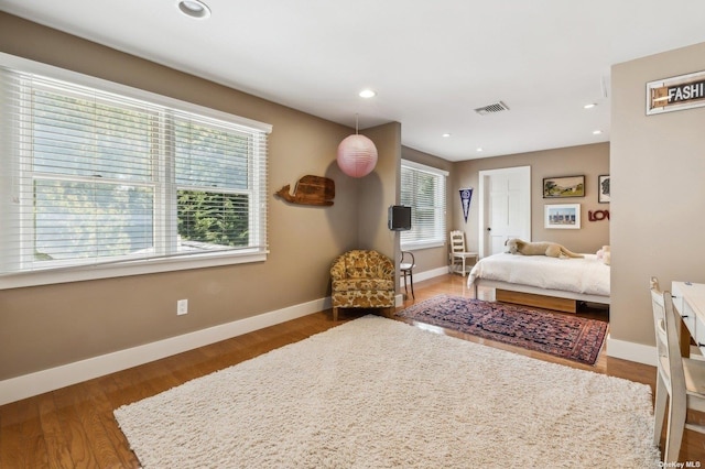 bedroom featuring dark hardwood / wood-style flooring and multiple windows