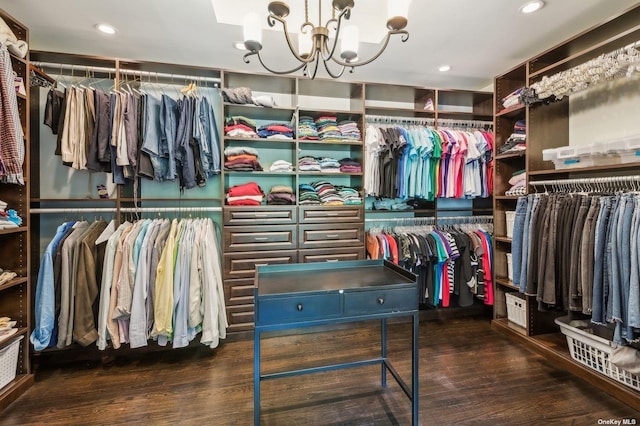 spacious closet with dark hardwood / wood-style floors and a notable chandelier