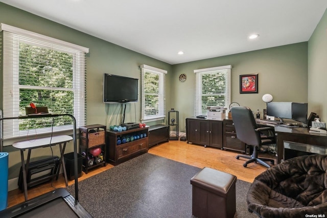 home office with light hardwood / wood-style flooring and a healthy amount of sunlight