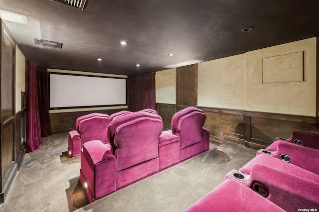 cinema room with light colored carpet and wooden walls