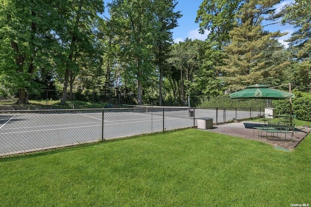 view of tennis court with a lawn