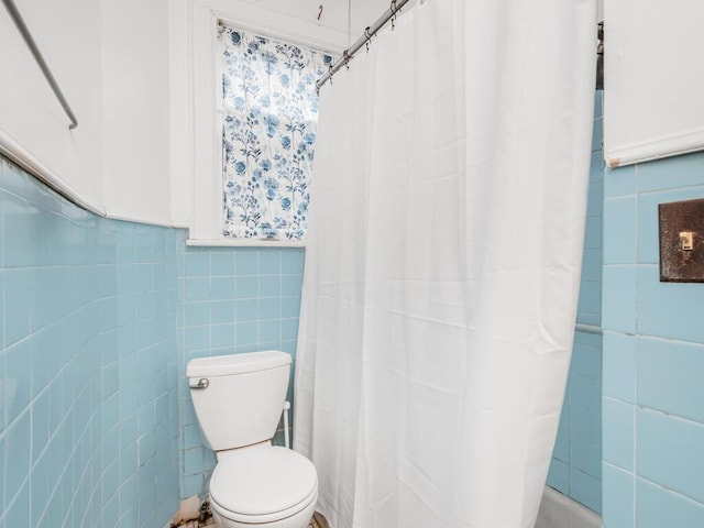 bathroom featuring tile walls and toilet