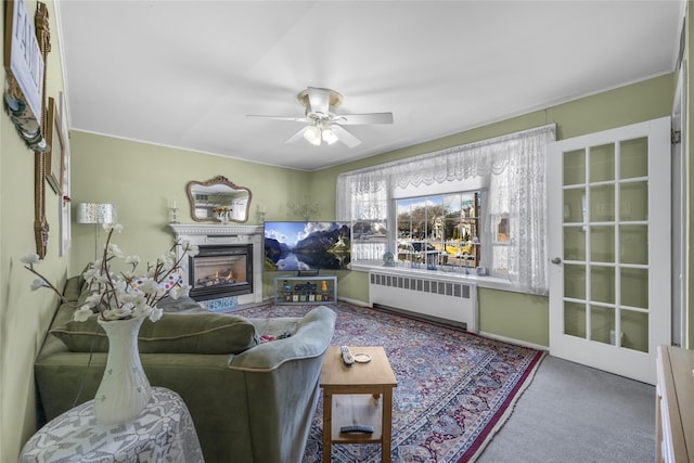 living room with ceiling fan, radiator heating unit, and carpet flooring