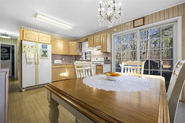 dining area with a chandelier and light wood-type flooring