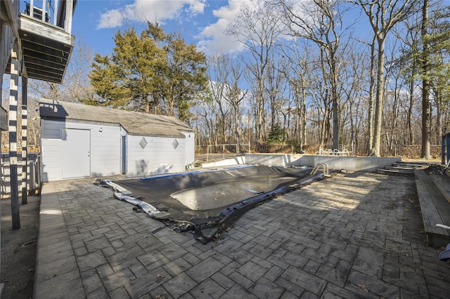 view of patio / terrace featuring an outbuilding and a covered pool