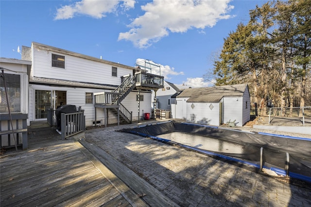 rear view of house with a swimming pool side deck and an outbuilding