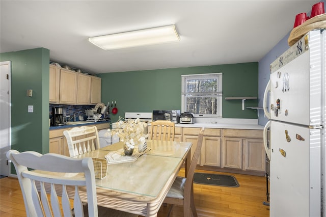 kitchen with decorative backsplash, light hardwood / wood-style flooring, white fridge, and light brown cabinets