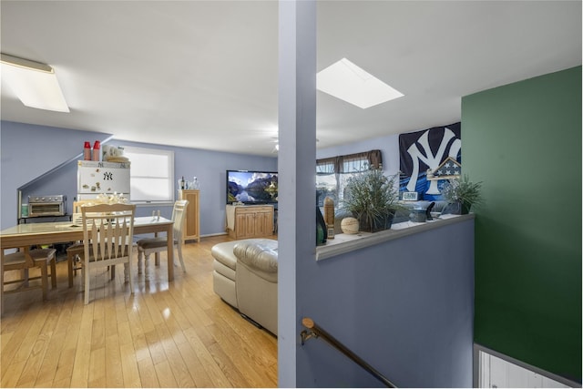 living room featuring a skylight and light wood-type flooring